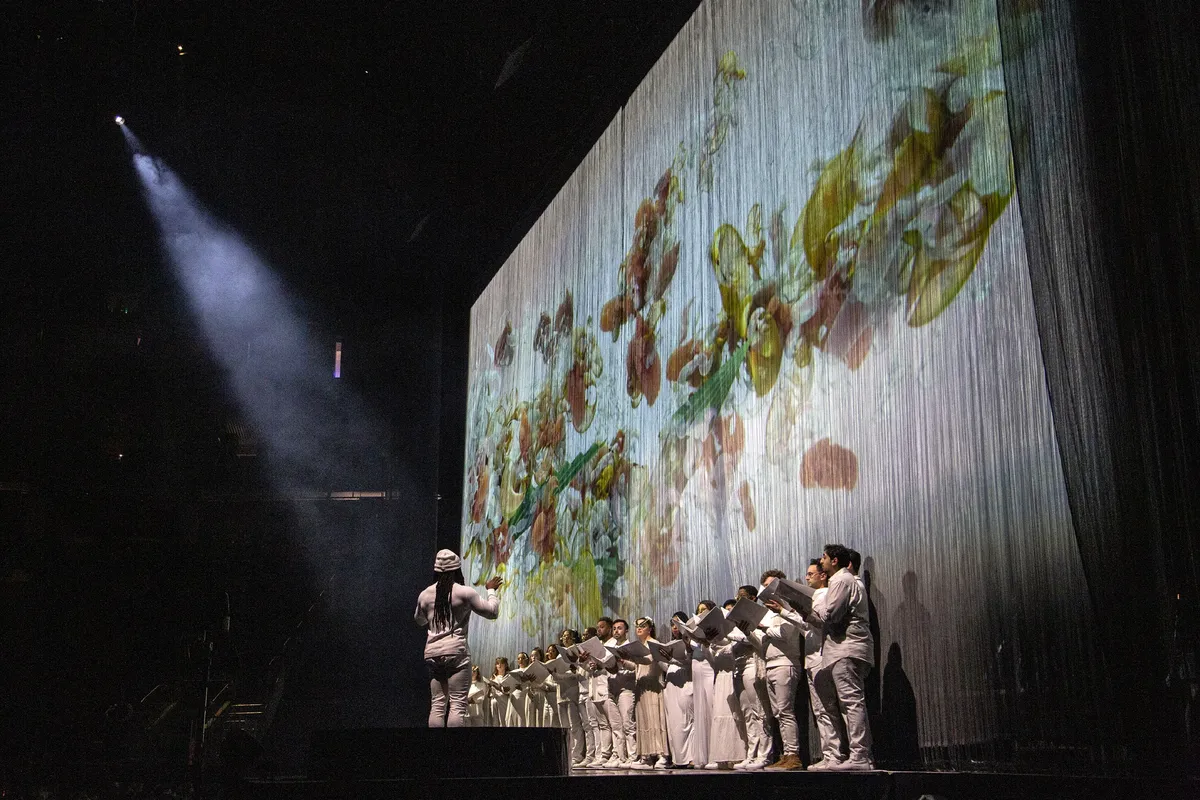 Alexander Blake conducting the Tonality choir on stage at a Björk concert.